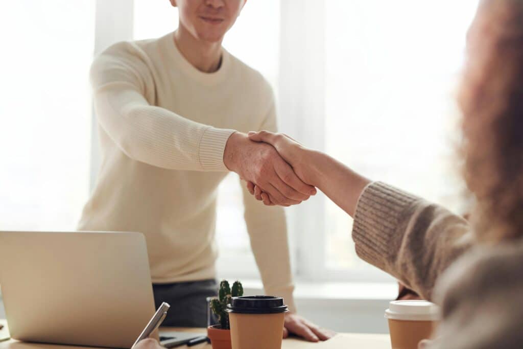 Admissions coach and student shaking hands during a strategic call