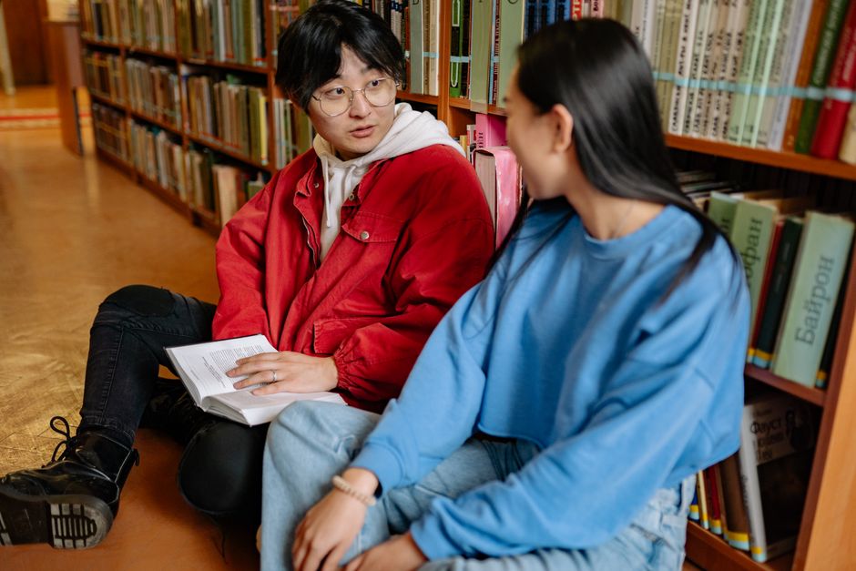Two students sitting on the library floo