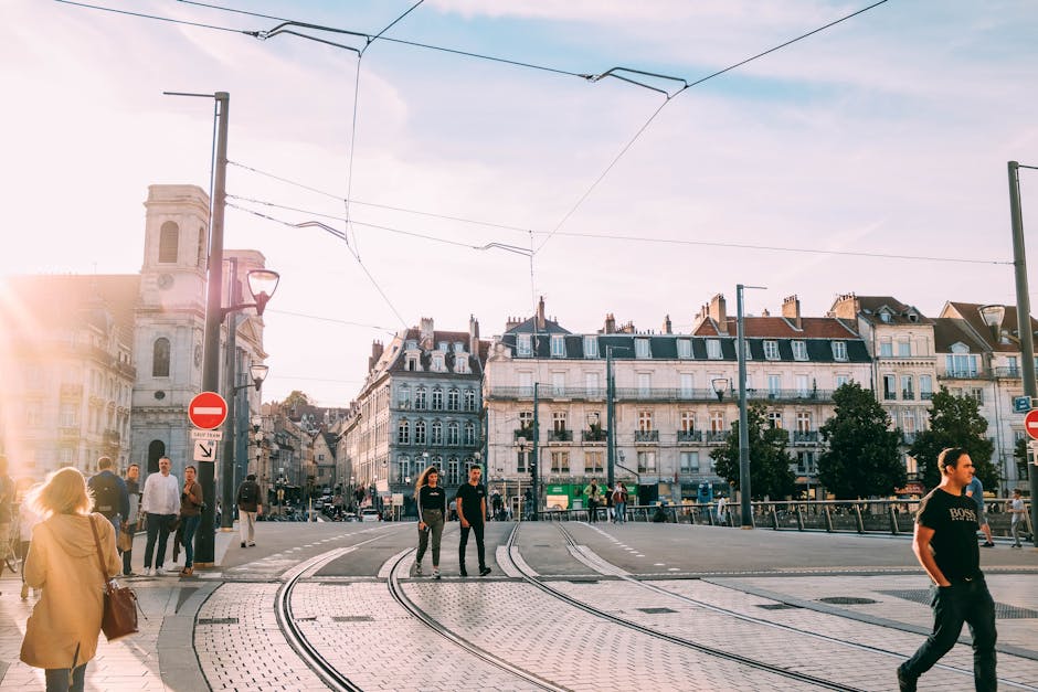 People walking across a sunny tramway in