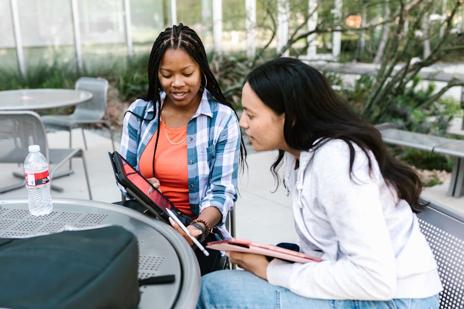 Two young women studying together using 