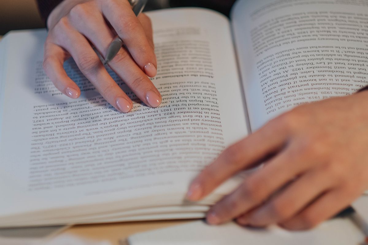 Student reading a book and taking notes